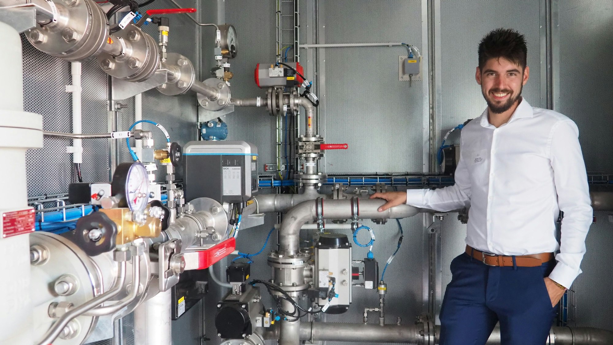 Ein Mann zeigt die Technik im Inneren eine Containers.