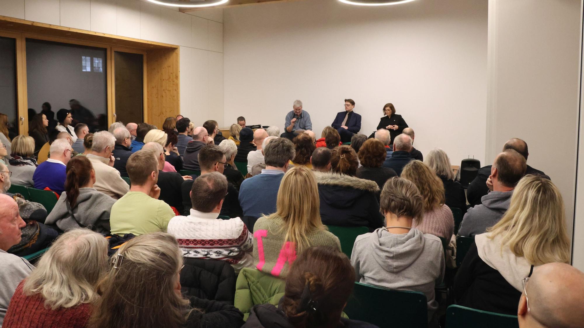 Menschen sitzen zusammen beim Gesprächsforum zur Flüchtlingssituation in Nümbrecht.
