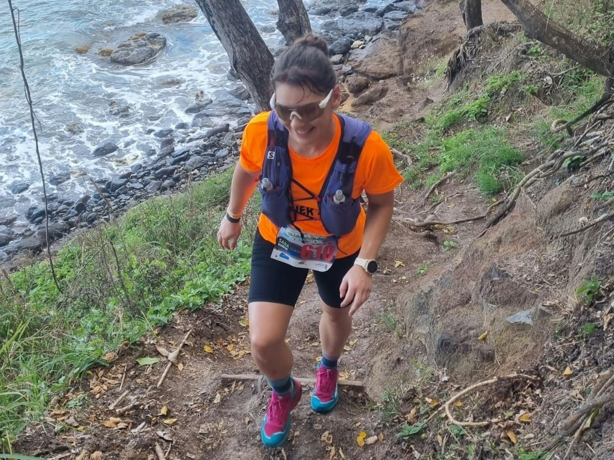 Sara Schütze läuft durch unwegsames Gelände an einem Gewässer entlang.