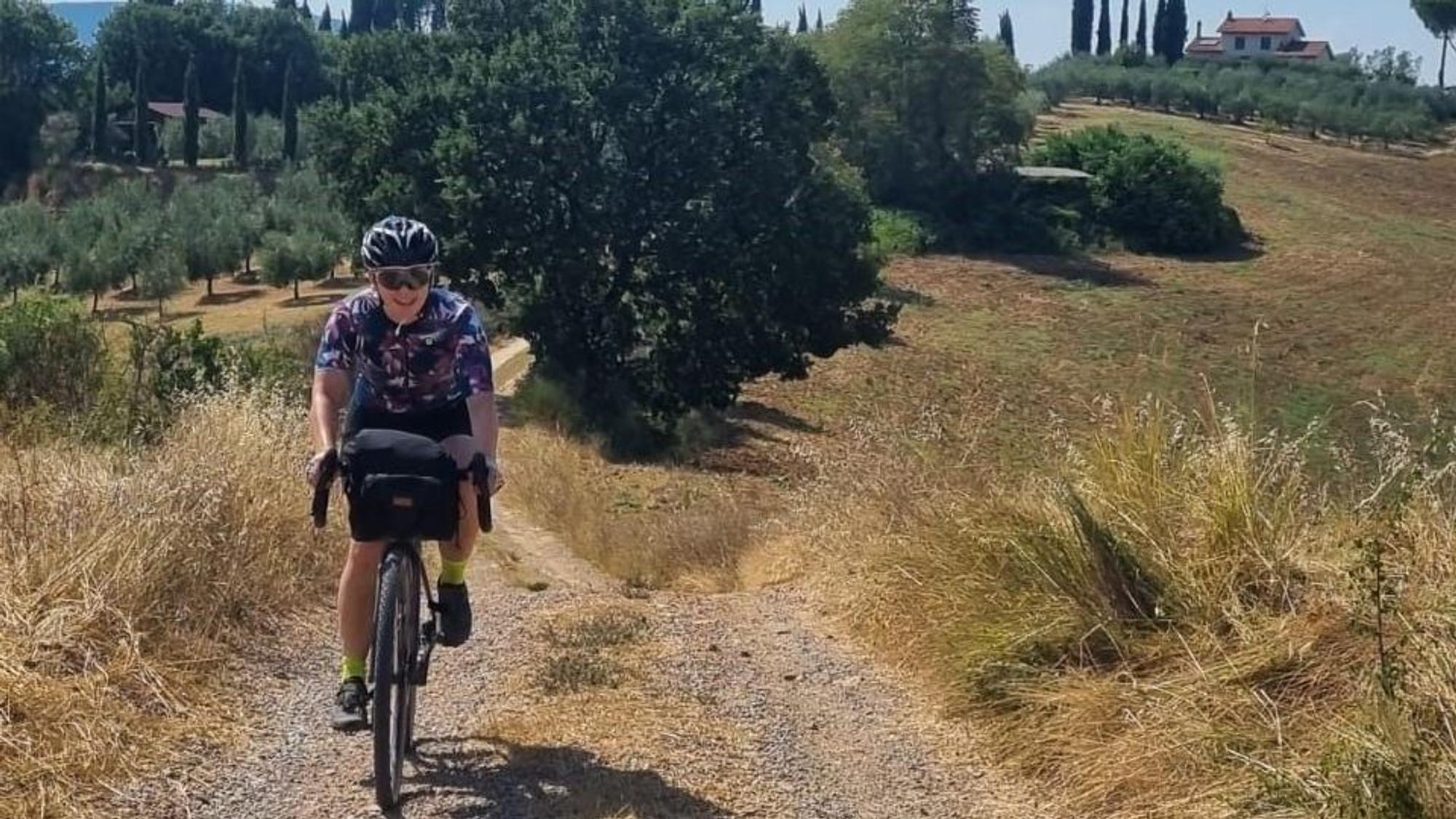 Sara Schütze fährt mit einem Rad über einen Feldweg in der Toskana.