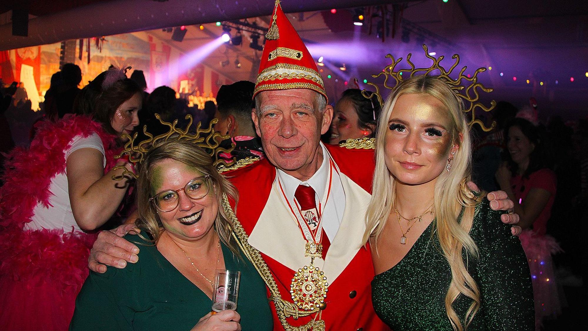 KG-Präsident Udo Kreitz hält die als Medusen verkleideten Frauen Sabina und Laura im Arm.