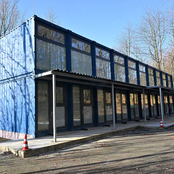 Blaue Schiffscontainer werden zu Geflüchtetenunterkünften umgebaut.