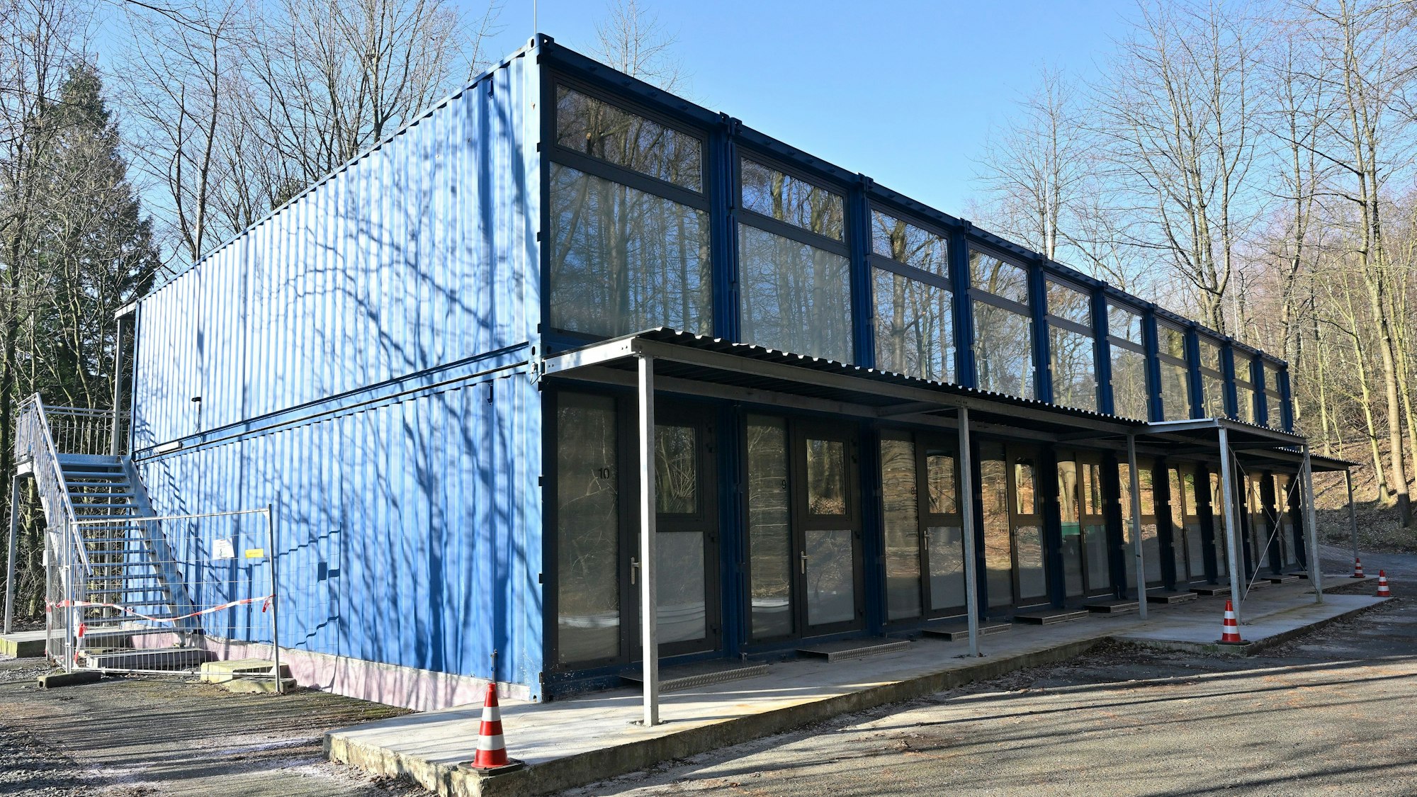 Blaue Schiffscontainer werden zu Geflüchtetenunterkünften umgebaut.