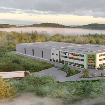 Ein rechteckiges Industriegebäude in bergiger Landschaft.