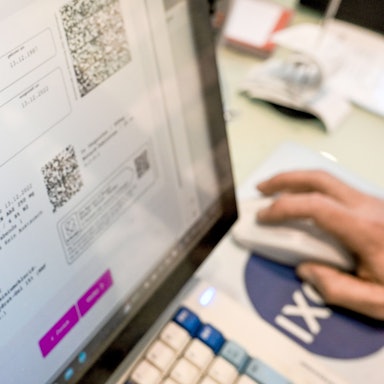 Auf einem Bildschirm in einer Apotheke sind Hinweise zu E-Rezepten angezeigt.