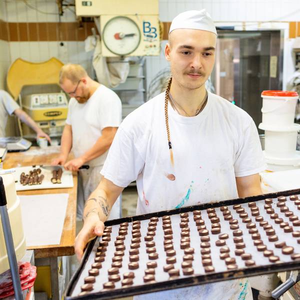 Der Bäcker Louis Braun trägt in der Bäckerei und Konditorei Lobenstein ein Blech voller Plätzchen zum Backofen.