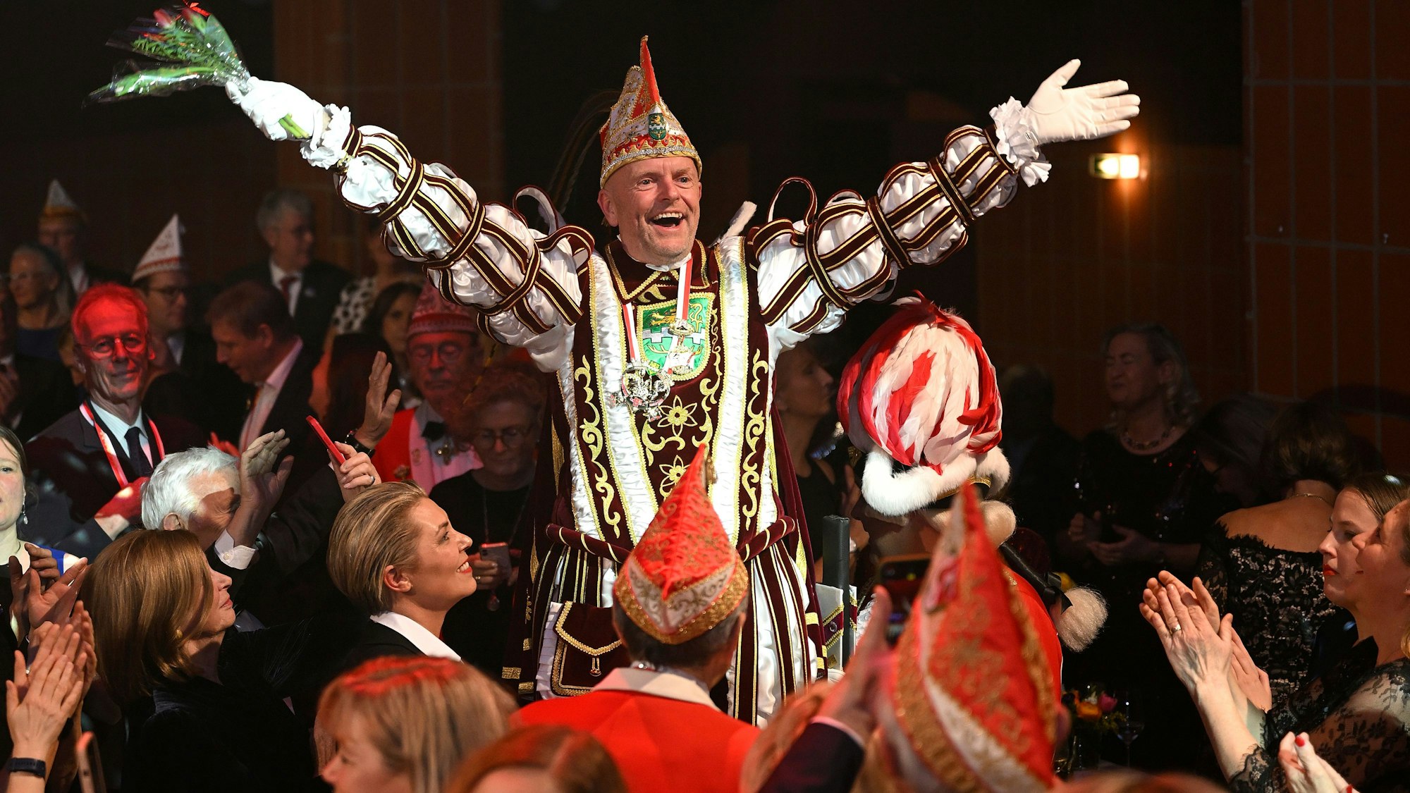 Prinz Andreas I. (Kaldenbach) steht auf einem Stuhl und jubelt über dem Publikum.