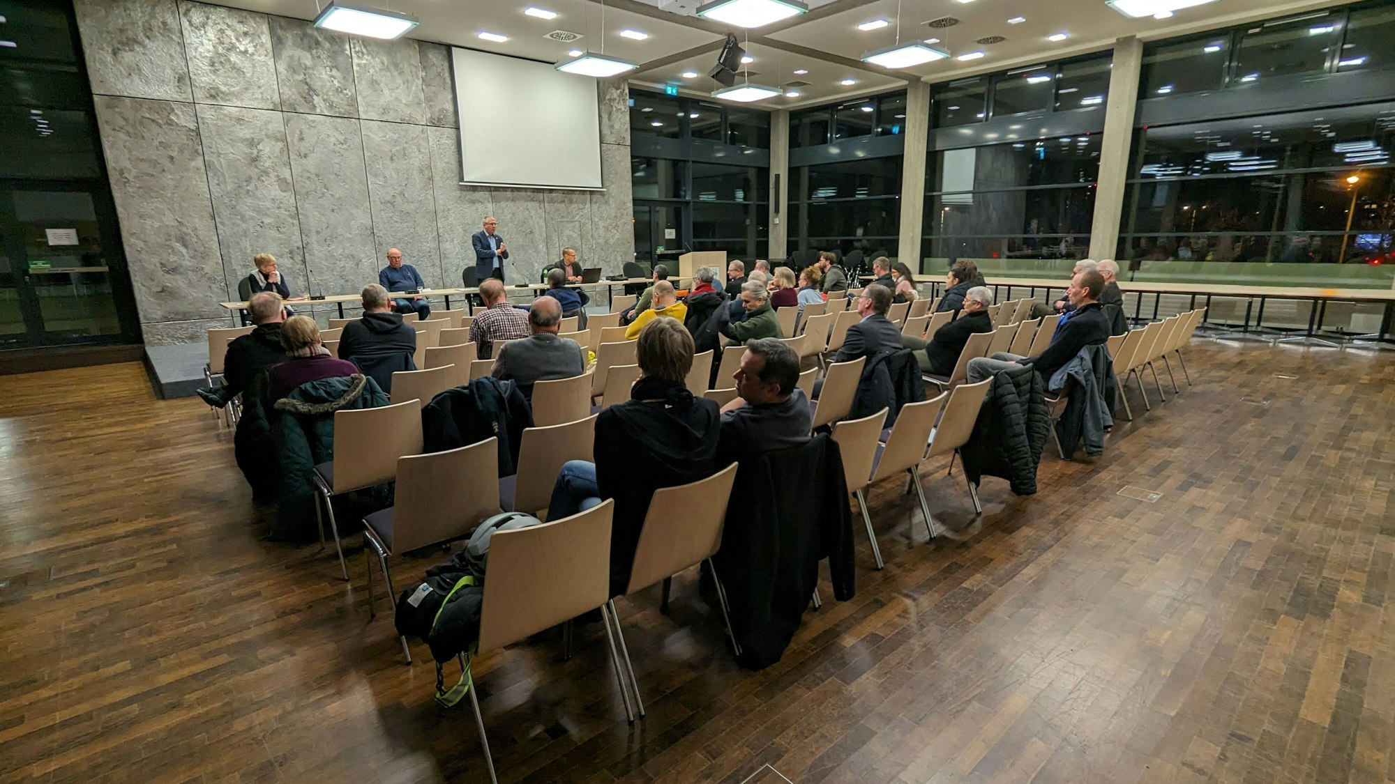 Bürger sitzen im Ratssaal von Roisdorf, vorne steht Bürgermeister Christoph Becker.