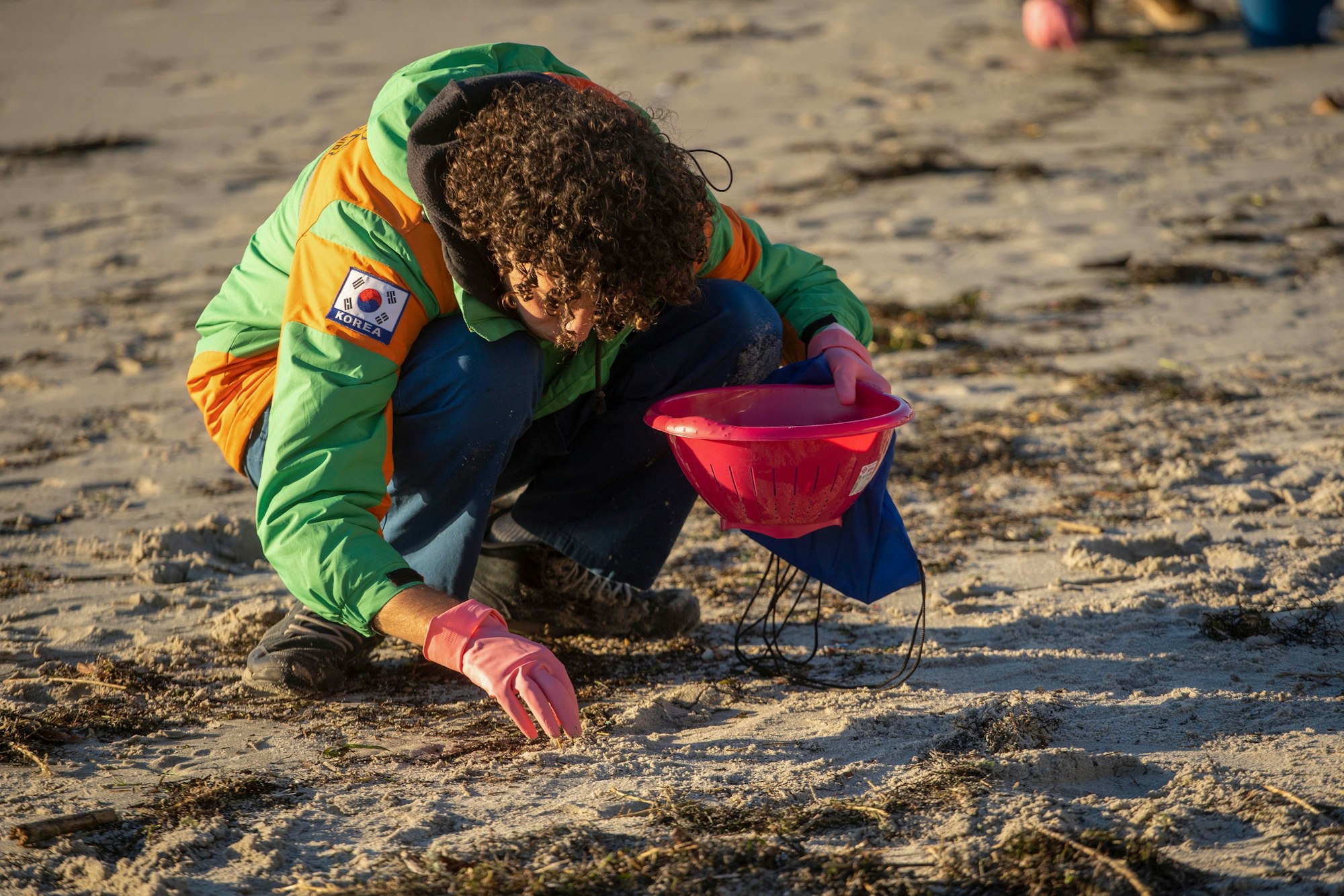 Pontevedra: Ein Freiwilliger sammelt mit einem Sieb am Strand Plastik ein.