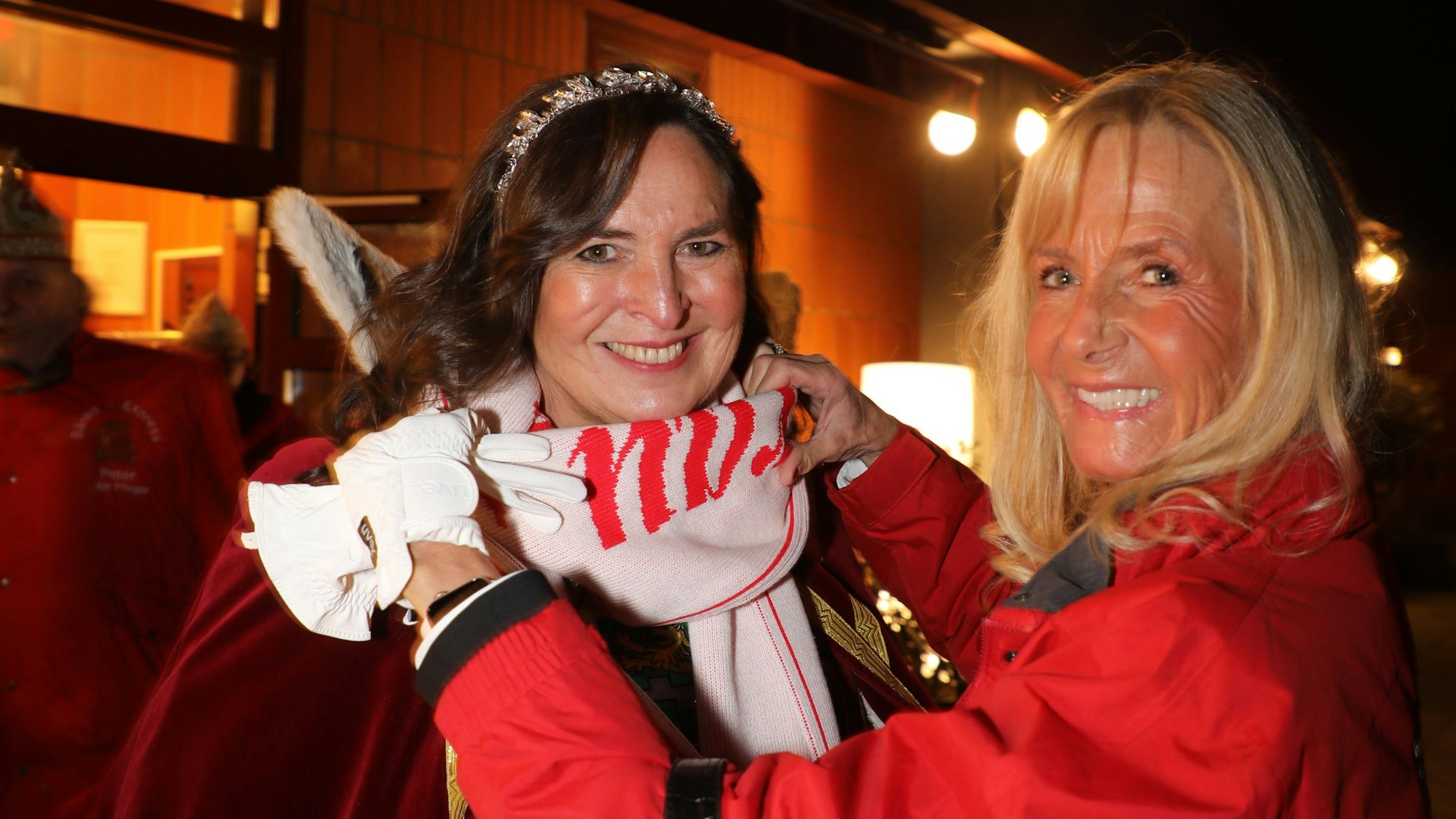 Adjutantin Andrea Habrunner bindet Bergisch Gladbachs Jungfrau Sabine (Auweiler) den Schal zu.