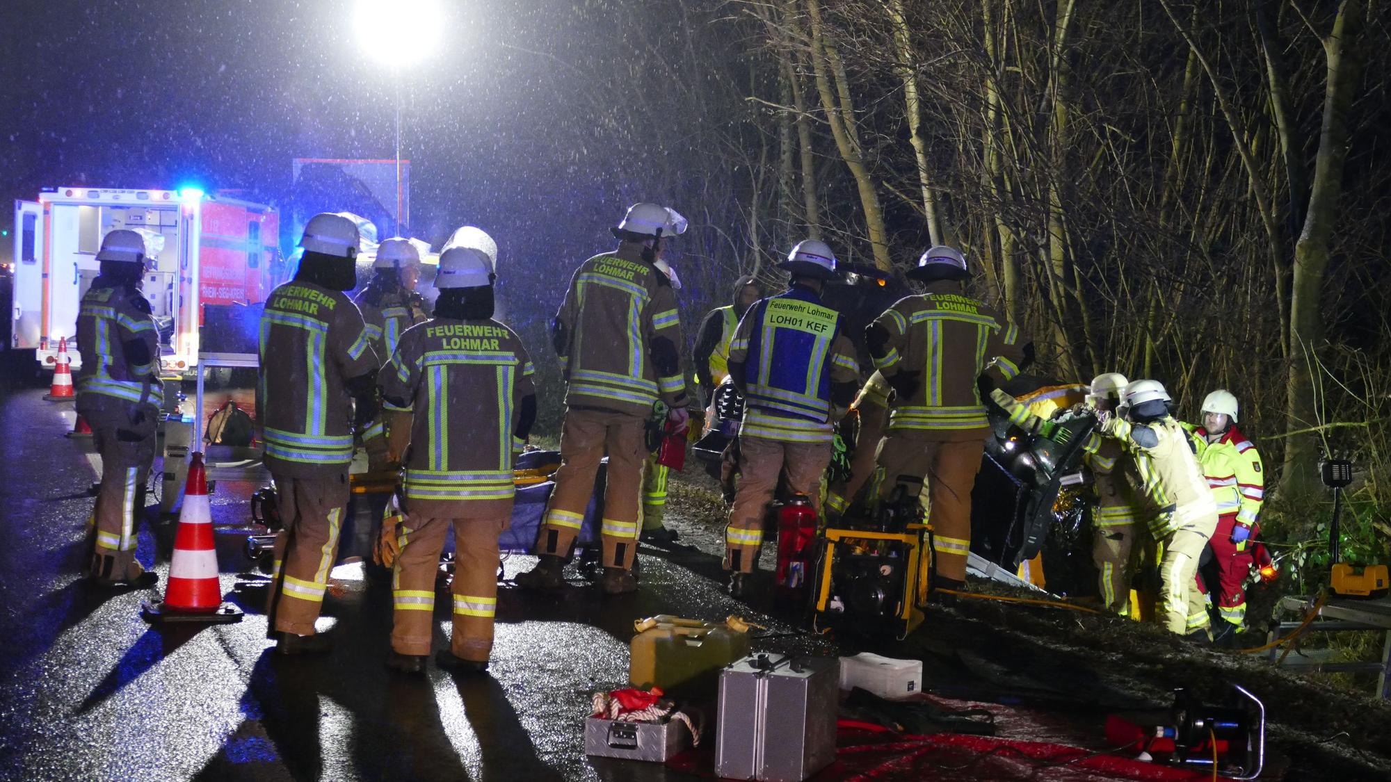 Feuerwehrleute befreien einen Verletzten aus seinem Auto.