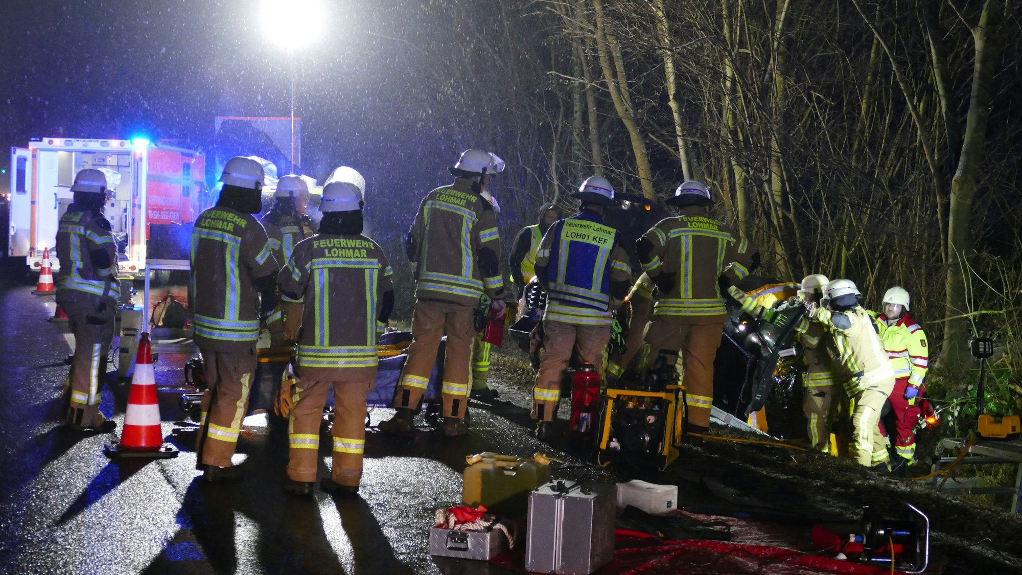 Feuerwehrleute befreien einen Verletzten aus seinem Auto.
