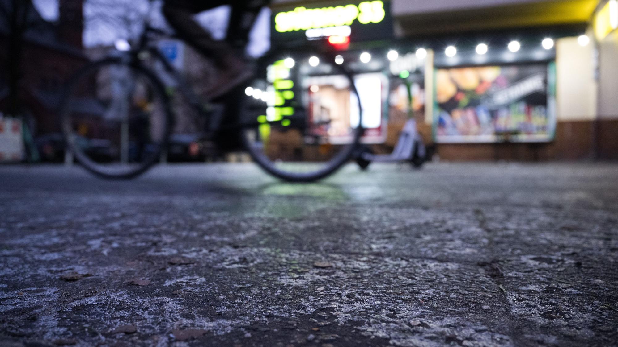 12.01.2024, Berlin: Ein Fahrradfahrer fährt auf einem Fahrradweg mit einer dünnen Eisschicht entlang. Nach Tagen mit Minusgraden kommt es nun zu glatten Straßen und Gehwegen. Foto: Sebastian Gollnow/dpa +++ dpa-Bildfunk +++