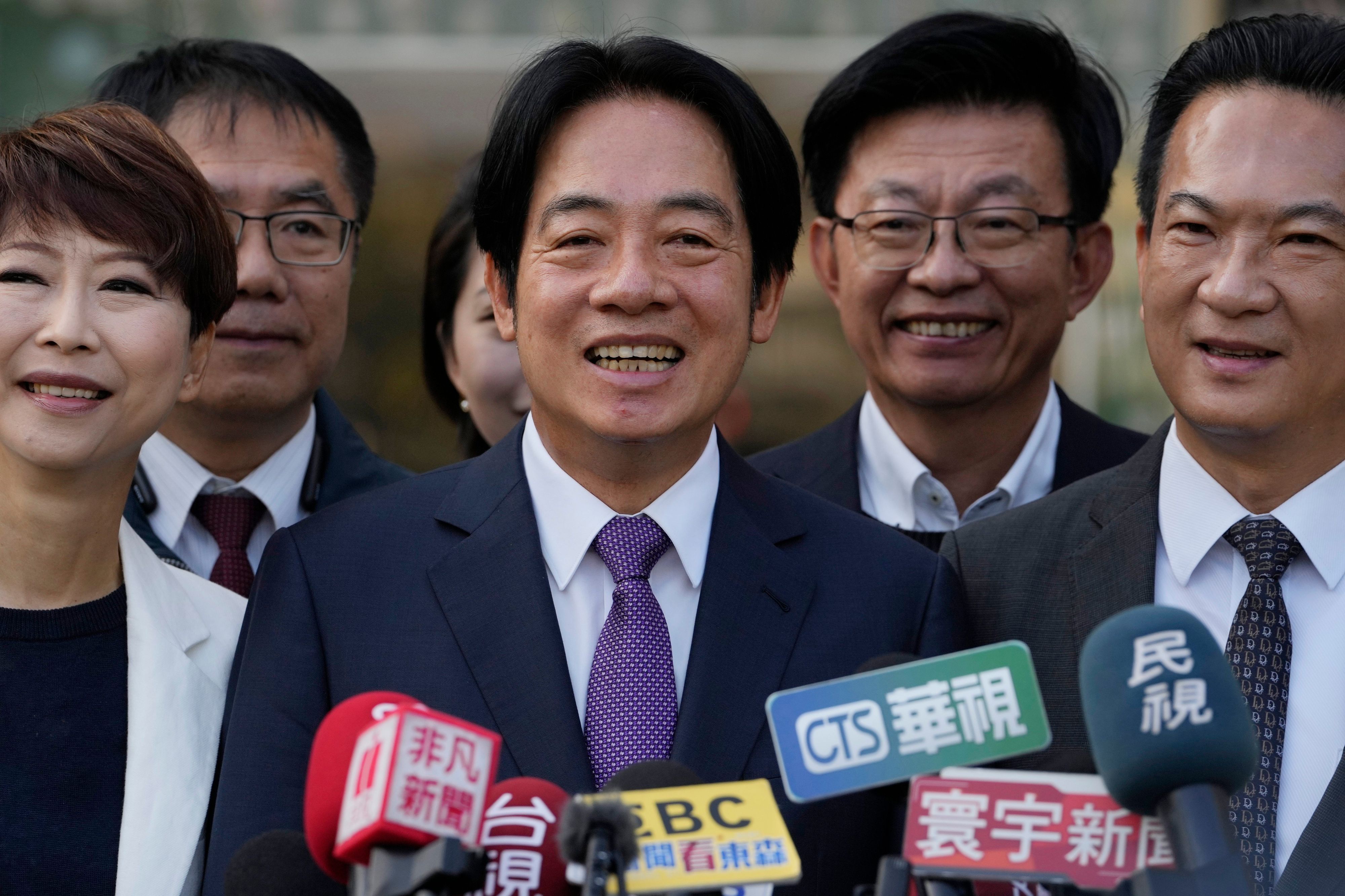 William Lai steht mit anderen Personen vor Mikrofonen.