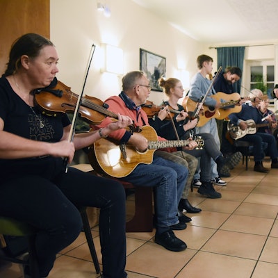 Mehrere Musiker mit diversen Instrumenten spielen gemeinsam Songs.