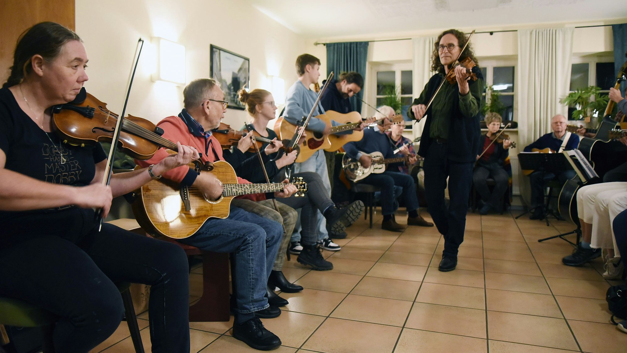 Mehrere Musiker mit diversen Instrumenten spielen gemeinsam Songs.