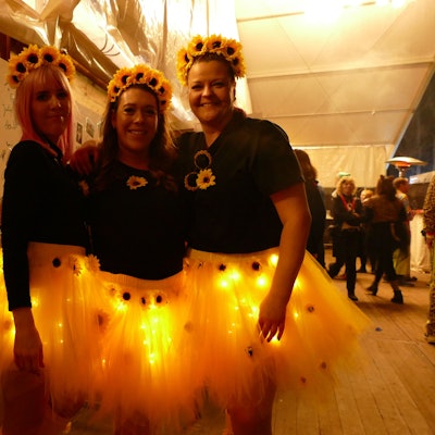 Drei Frauen als Sonnenblumen verkleidet.