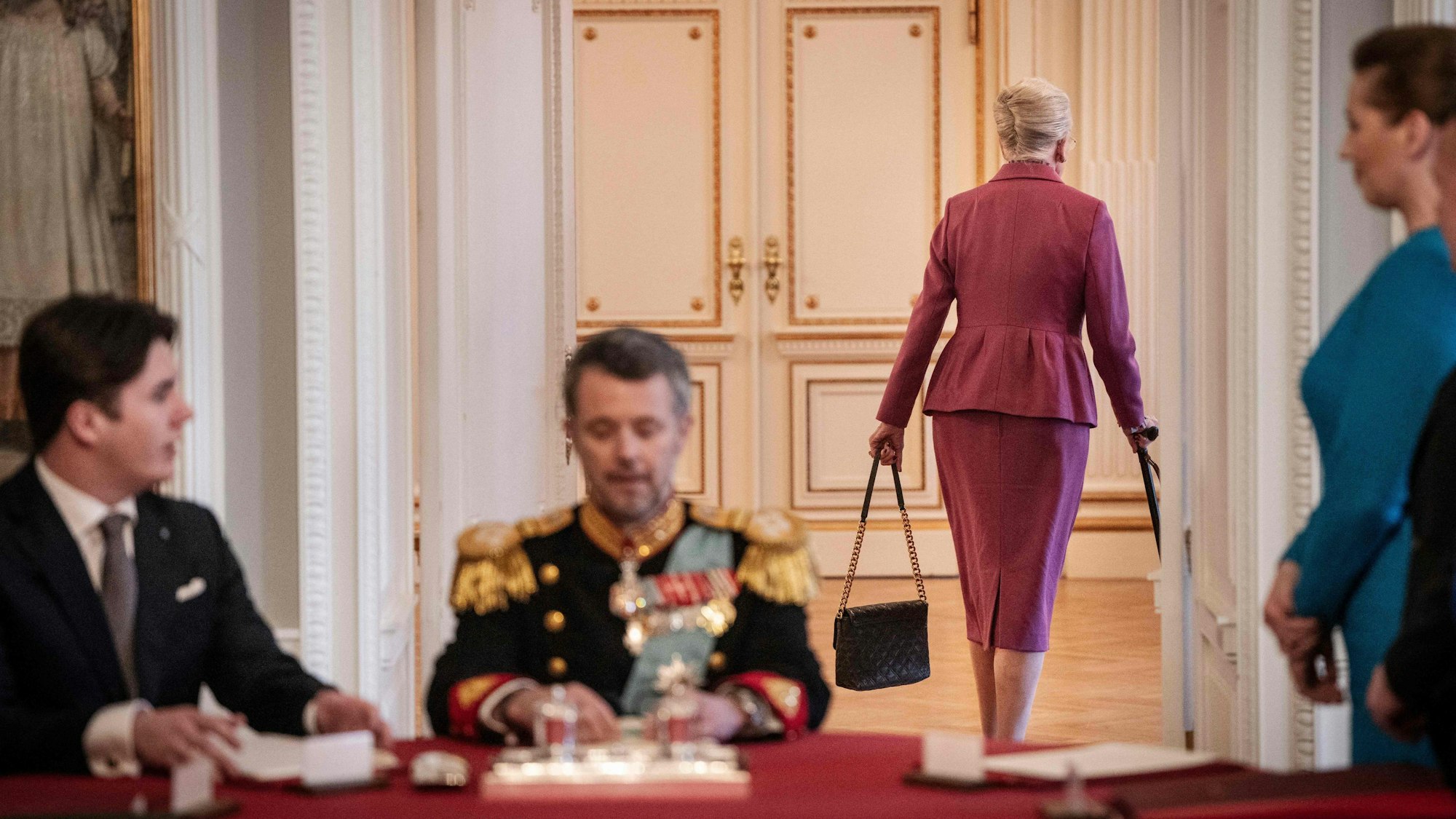 Nach der Unterzeichnung der Abdankungserklärung überlässt Königin Margrethe II. von Dänemark (2.v.r.) ihrem Sohn König Frederik X. von Dänemark den Platz am Kopfende des Tisches, während Prinz Christian von Dänemark (l.) und die dänische Ministerpräsidentin Mette Frederiksen (r.) während der Sitzung des Staatsrats im Schloss Christiansborg in Kopenhagen zusehen.