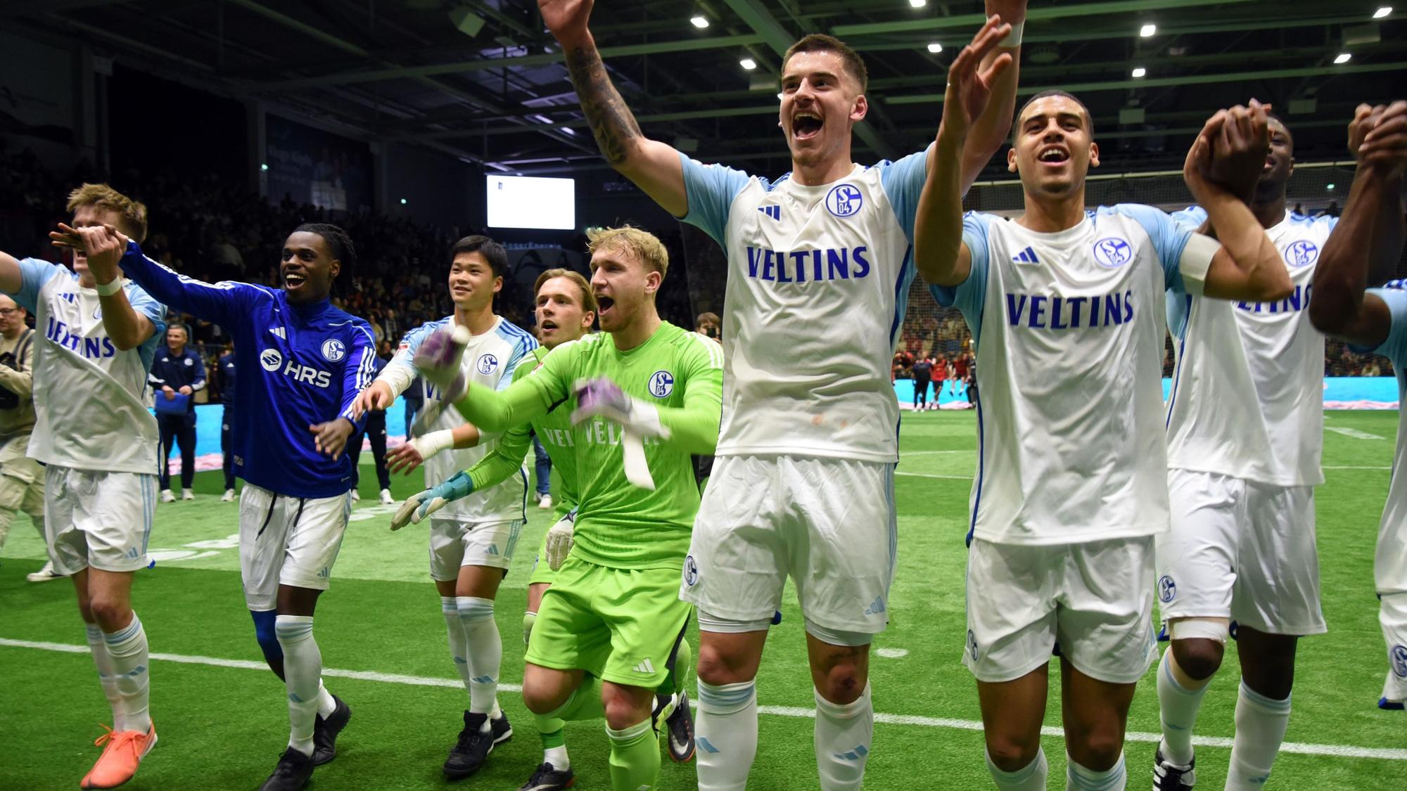 Die Schalker Fußballer reißen die Arme hoch und jubeln ihren Fans zu.