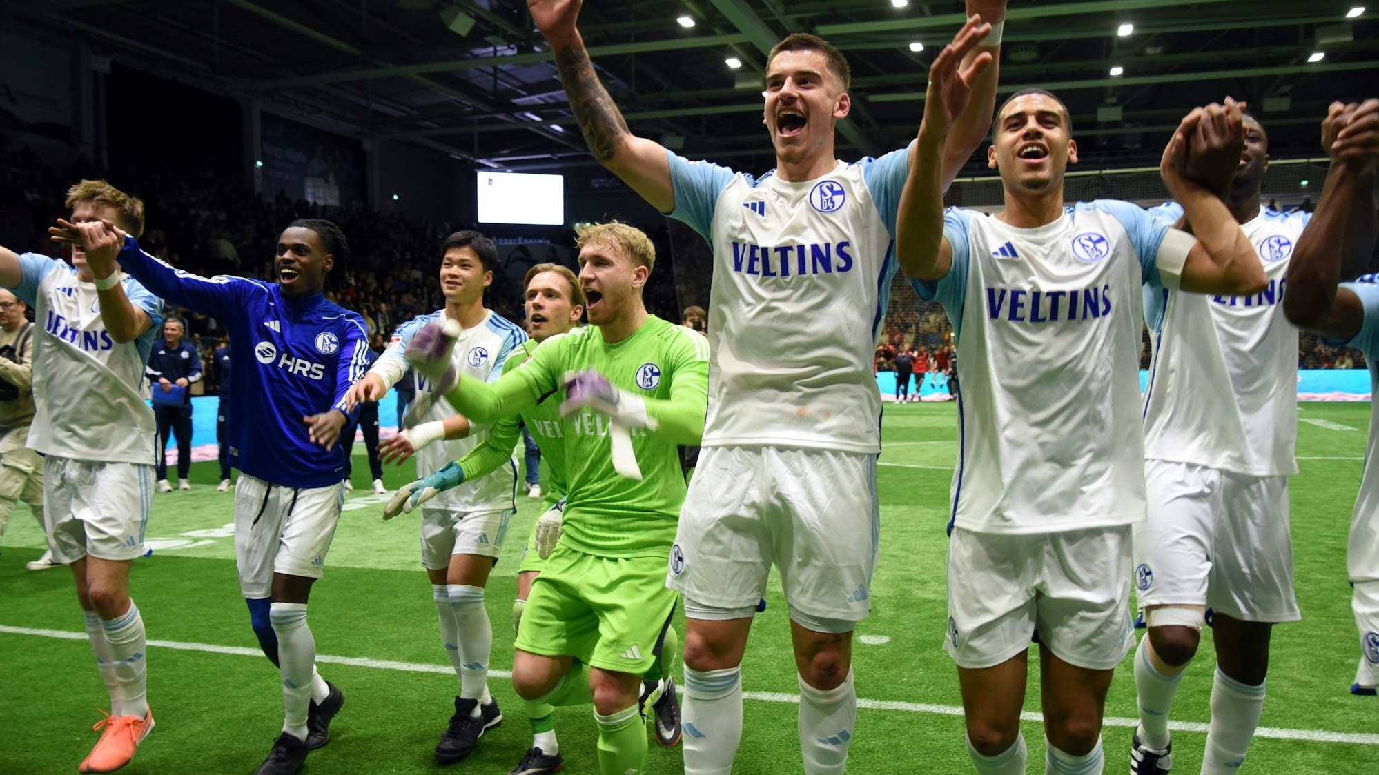 Die Schalker Fußballer reißen die Arme hoch und jubeln ihren Fans zu.