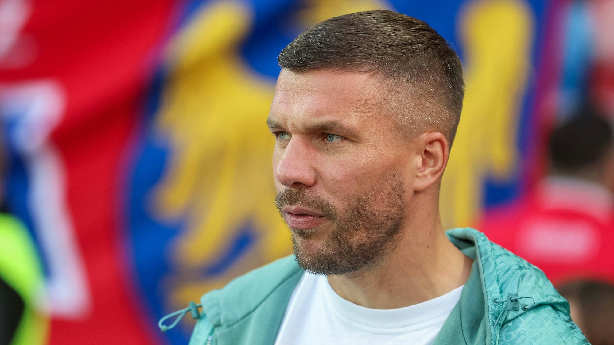 Lukas Podolski blickt kritisch in die Ferne.