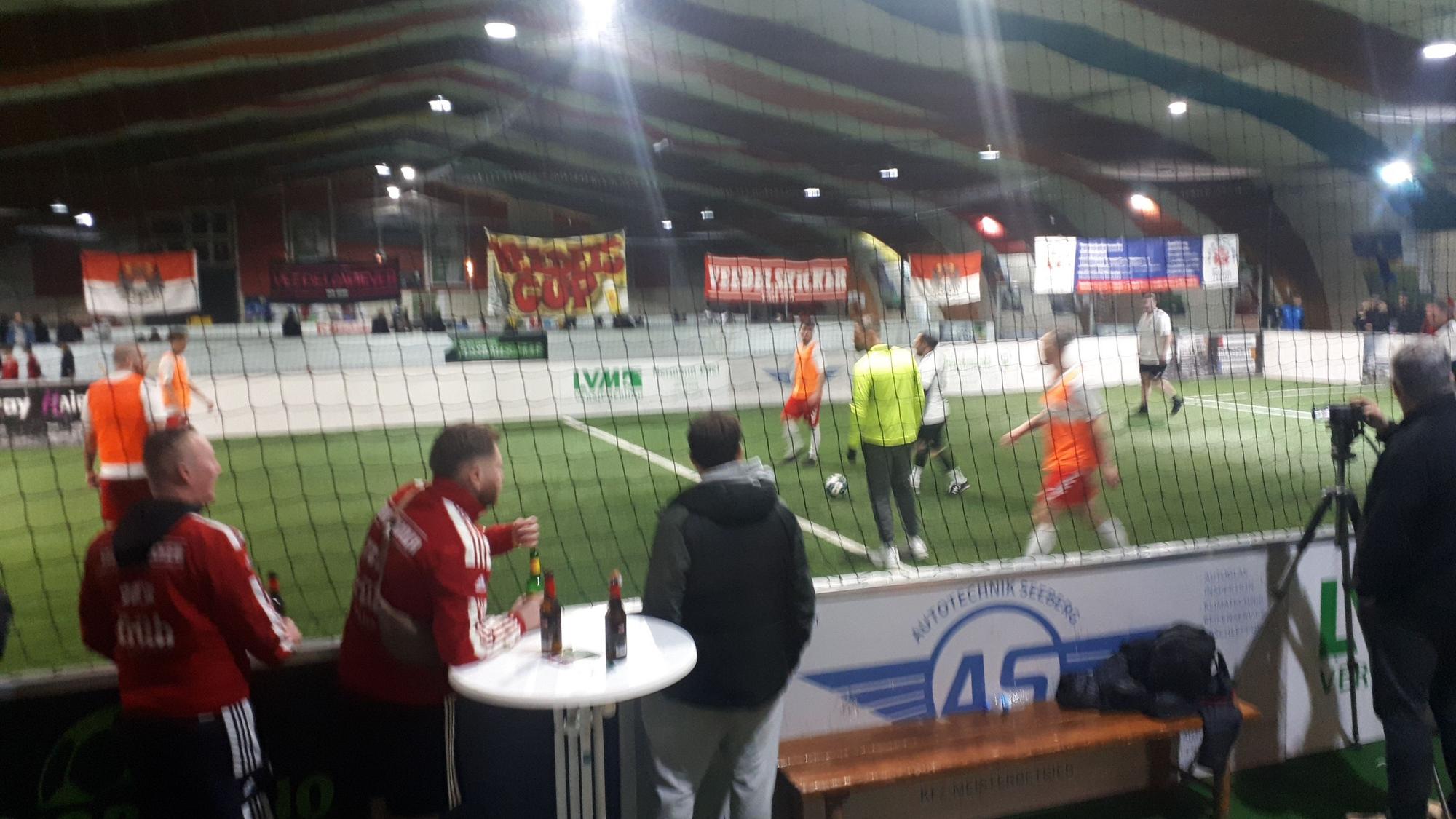 Auf einem Hallenplatz wird Fußball gespielt.