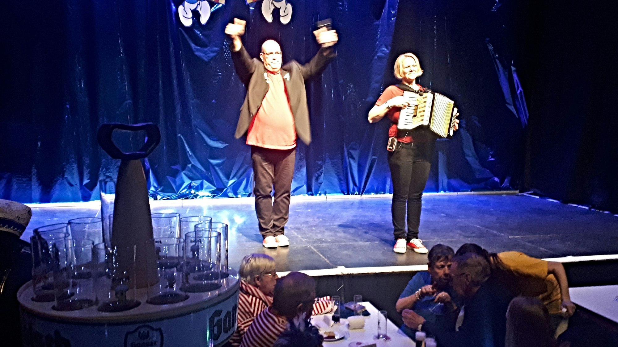 Ein Mann und eine Frau mit Akkordeon stehen auf einer Bühne.
