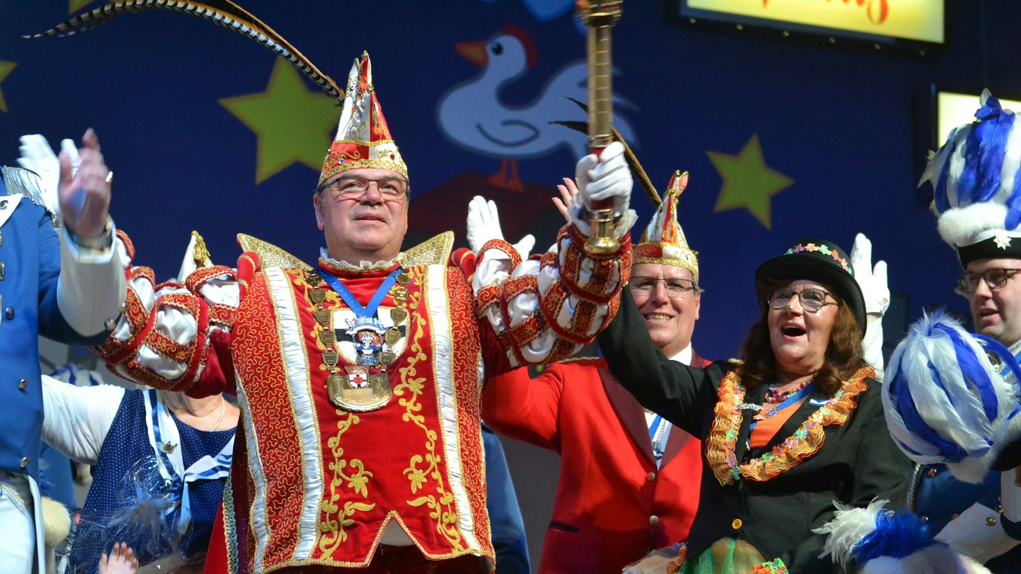 Prinz Ralf lässt sich feiern, neben und hinter ihm stehen weitere Karnevalisten auf der Bühne.