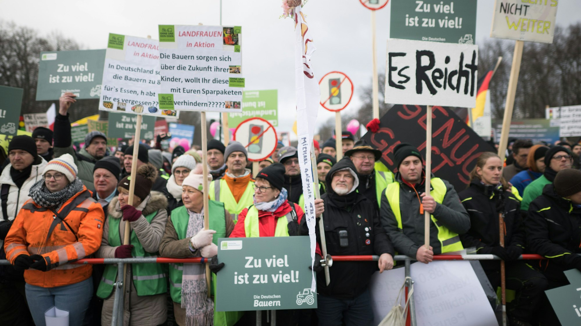 15.01.2024, Berlin: Demonstrationsteilnehmer stehen mit Plakaten während einer Protestdemonstration vor dem Brandenburger Tor. Zu einer Großdemonstration der Bauernverbände und des Speditionsverbands BGL werden laut Polizei etwa 10 000 Teilnehmer und 5000 Fahrzeuge erwartet.