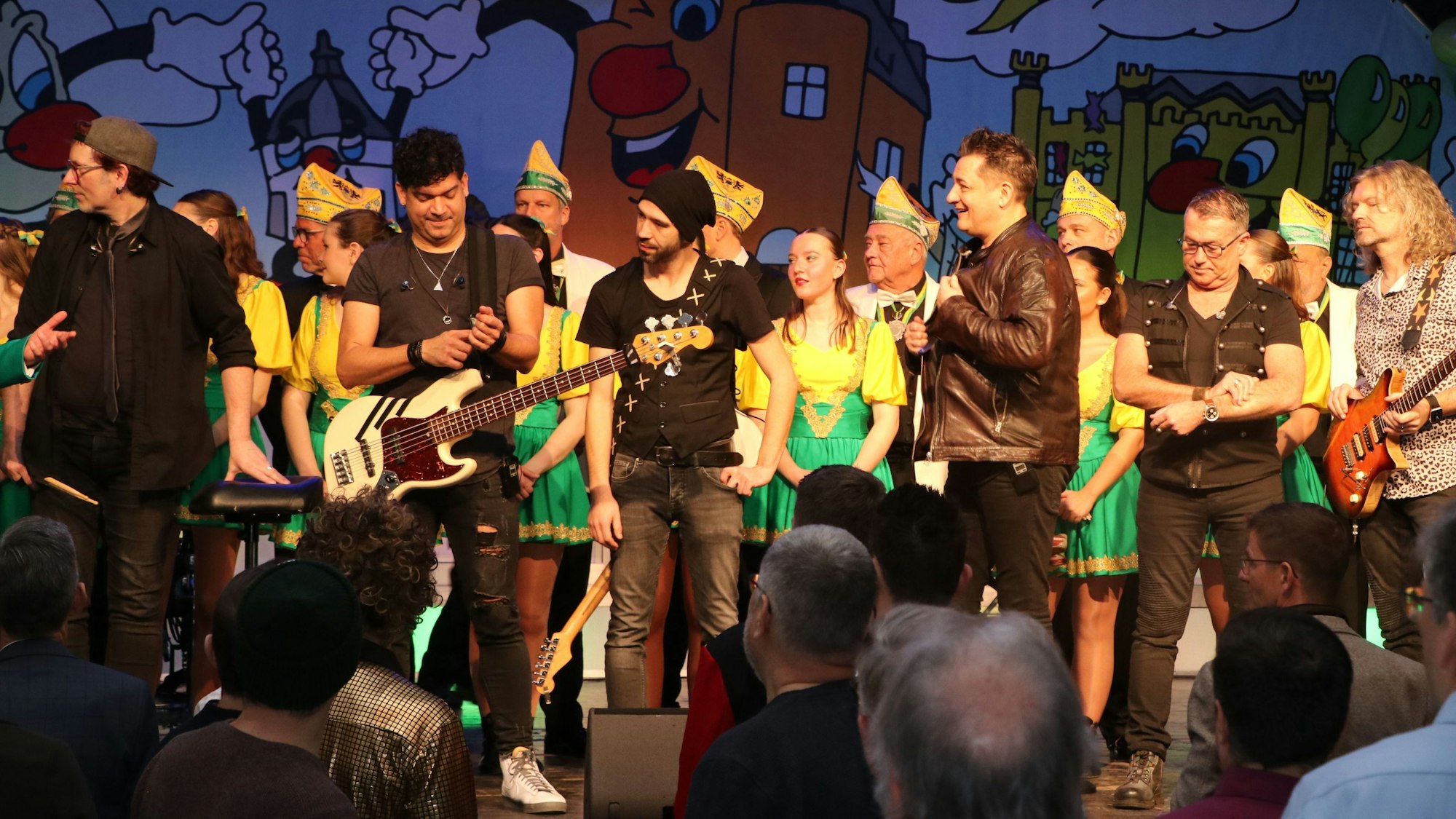 Musiker stehen bei einer Karnevalssitzung auf der Bühne.