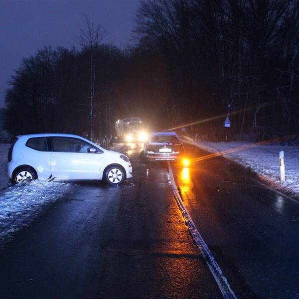 Zwei Unfallautos stehen in der Dämmerung auf einer Straße bei Kürten-Spitze.