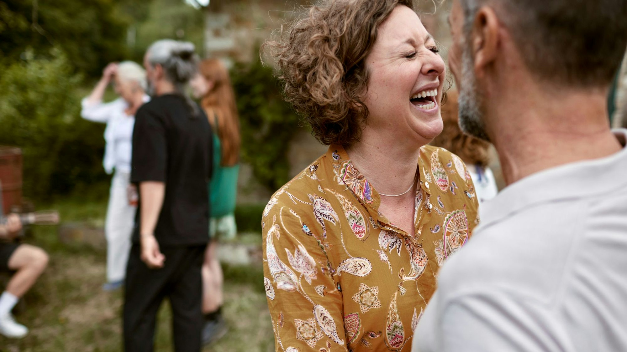 Eine lachende Frau im Gespräch mit einem Mann.