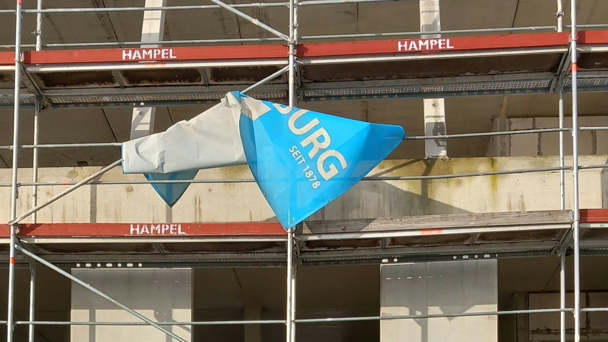 Das Banner des Investors hat sich um das nicht genutzte Gerüst gewickelt