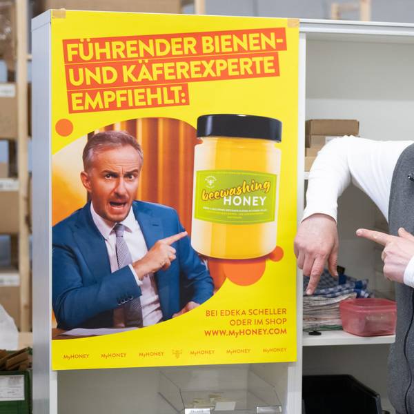 Rico Heinzig, Imker, steht neben einem Plakat mit dem Foto des Moderators Jan Böhmermann. Böhmermann verklagt den Imker.