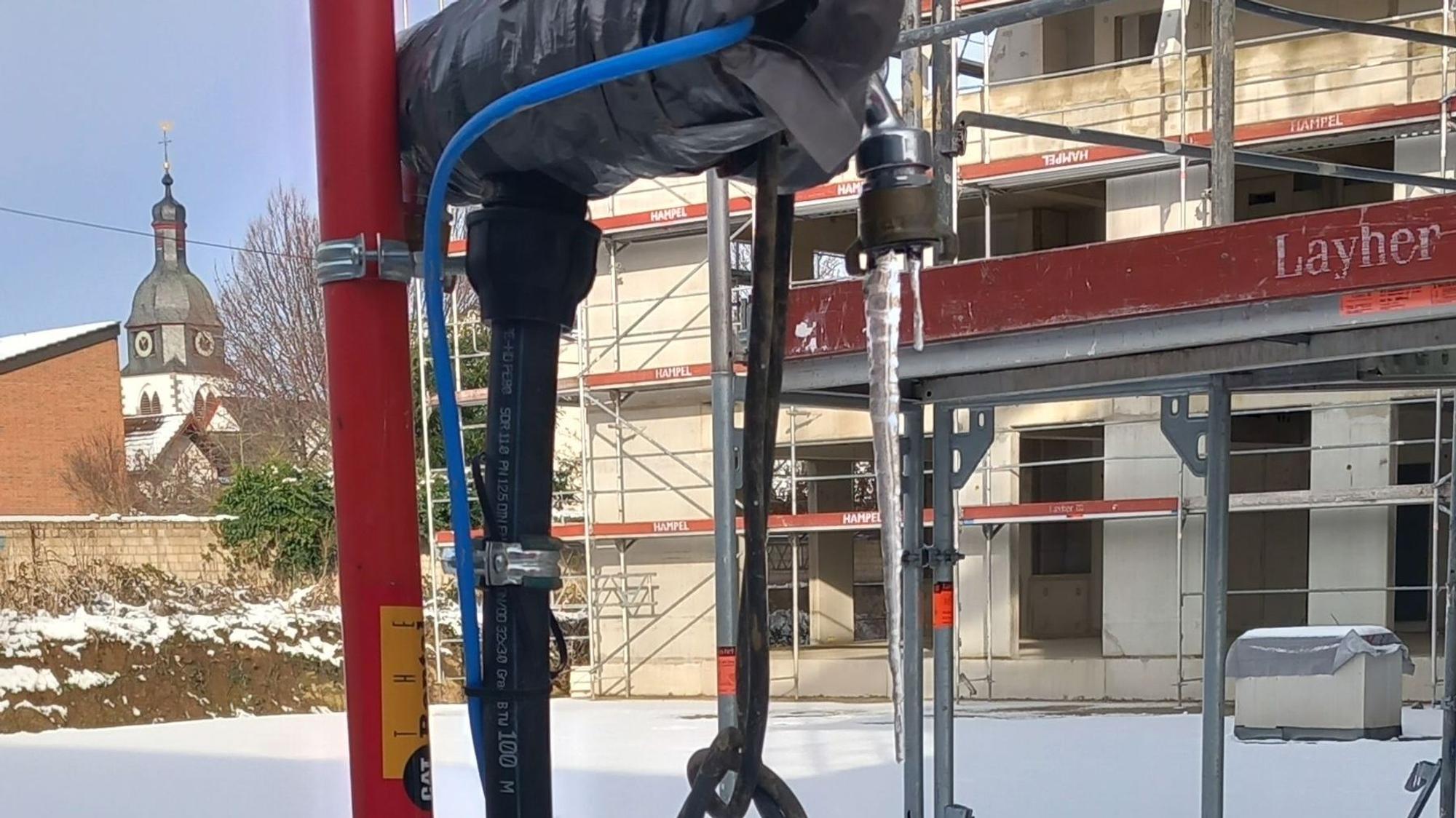 Eiszapfen an einer Wasserentnahmestelle auf der Baustelle des Pallotti