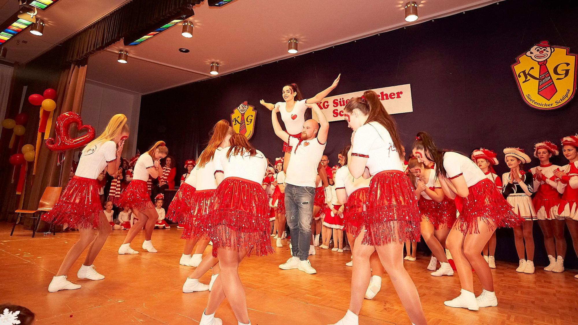 Frauen der Showtanzgruppe IG Ländchen tanzen in roten Röcken und weißen T-Shirts auf der Bühne.