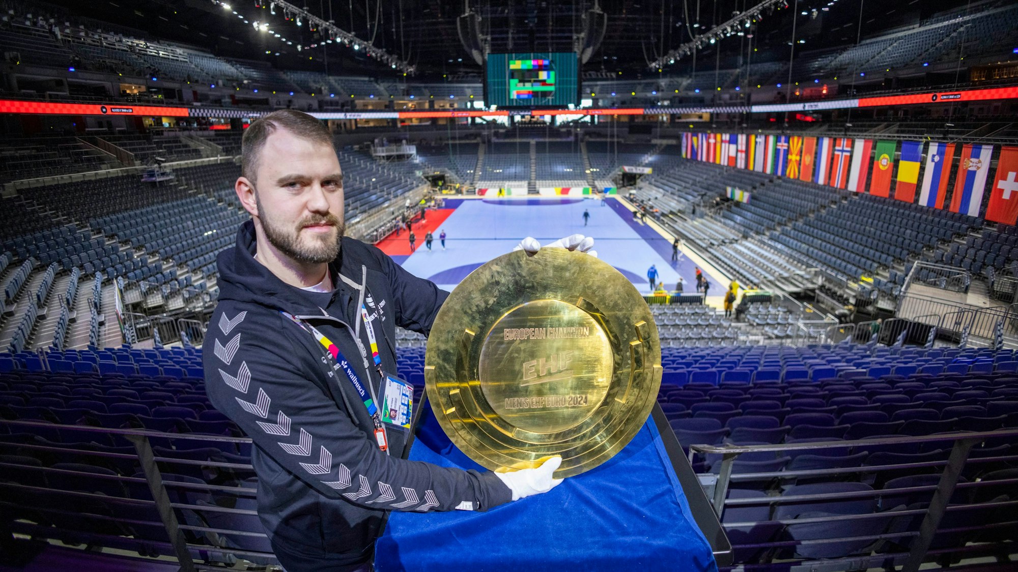 Carsten Heling, Local Media Manager der Lanxess-Arena, zeigt das Objekt der Begierde bei der Handball-Europameisterschaft: die EM-Schale.
