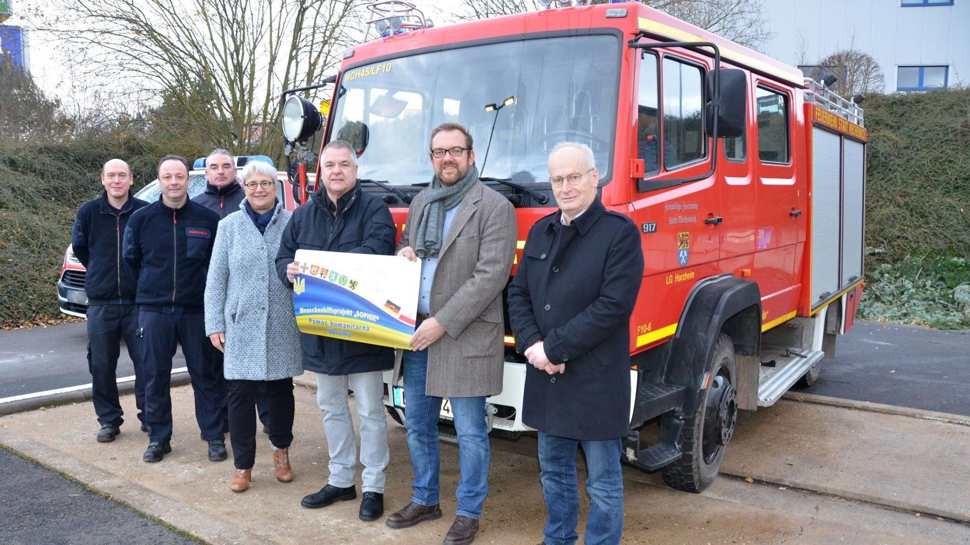 Mehrere Personen stehen in Mechernich vor einem Feuerwehrfahrzeug.