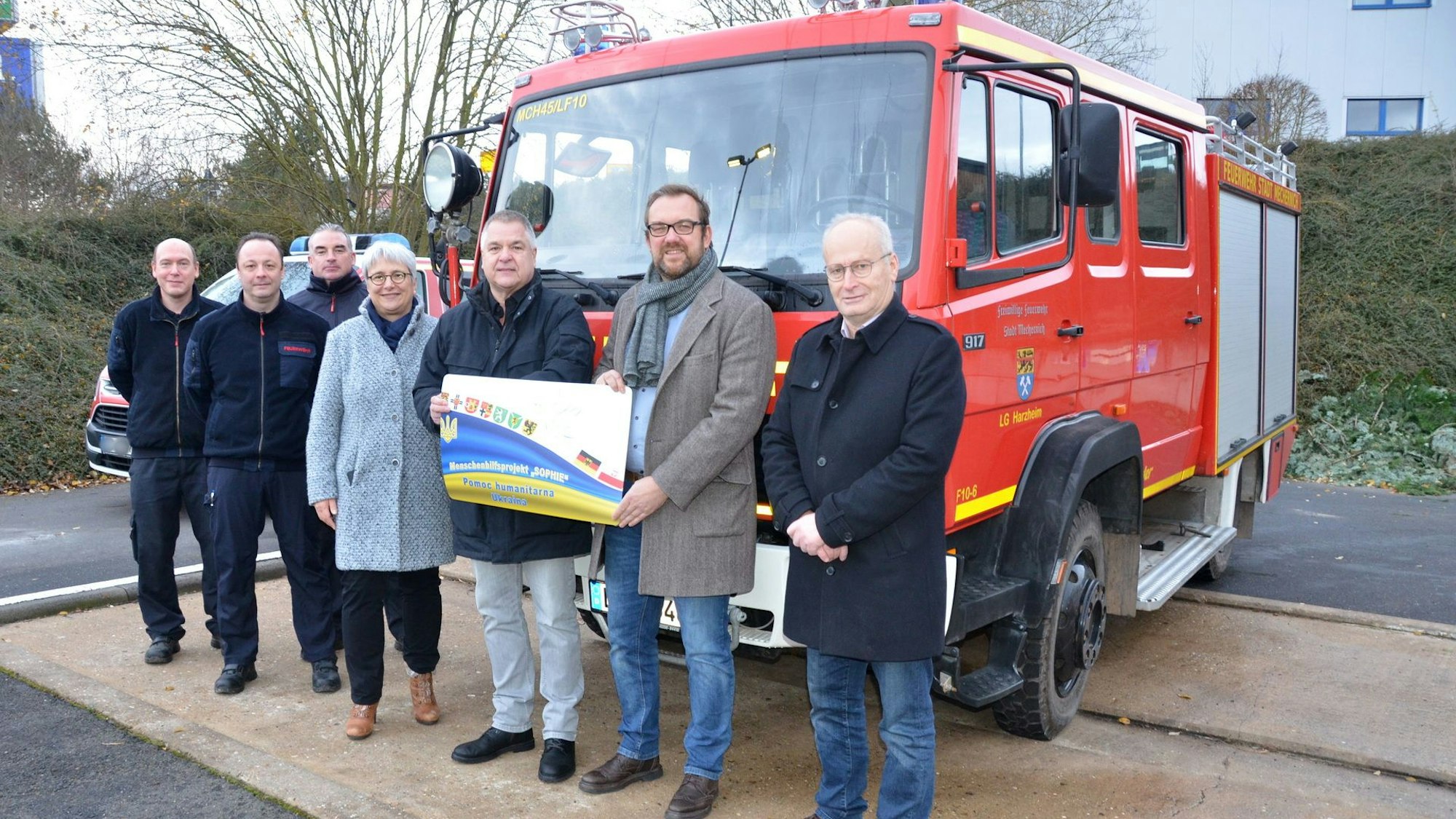 Mehrere Personen stehen in Mechernich vor einem Feuerwehrfahrzeug.