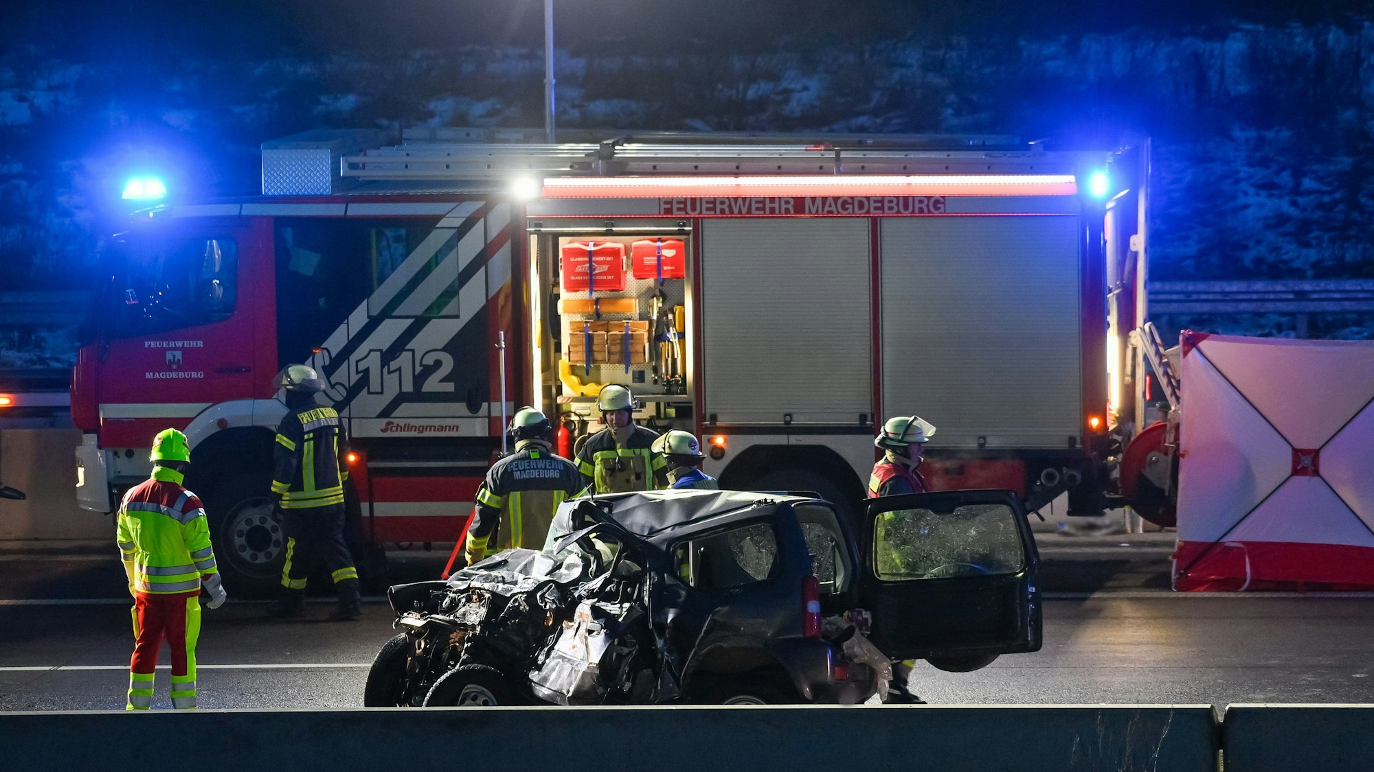 Feuerwehrleute stehen auf der Autobahn A2 an einer Unfallstelle.