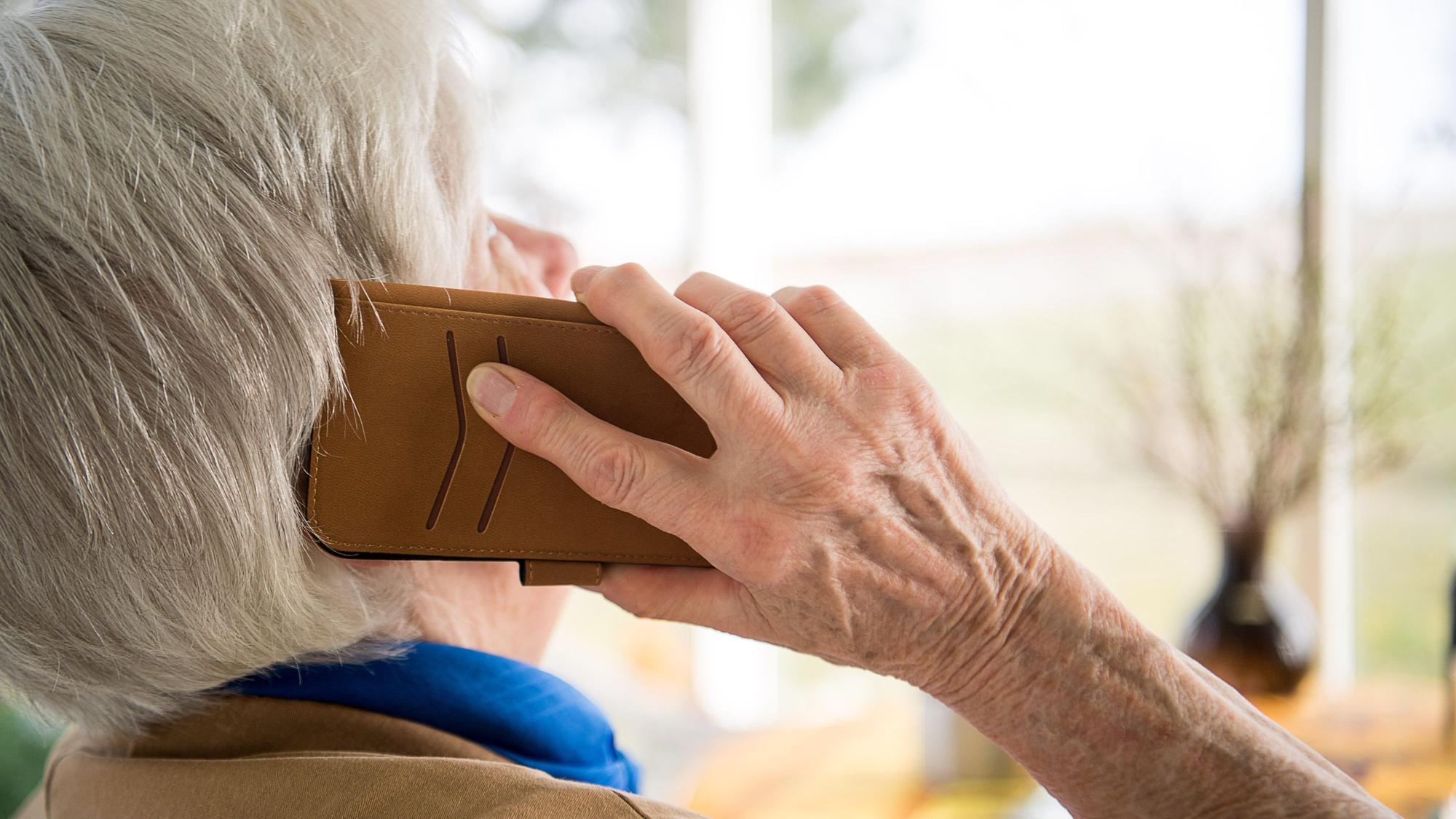 Eine Seniorin telefoniert mit ihrem Smartphone