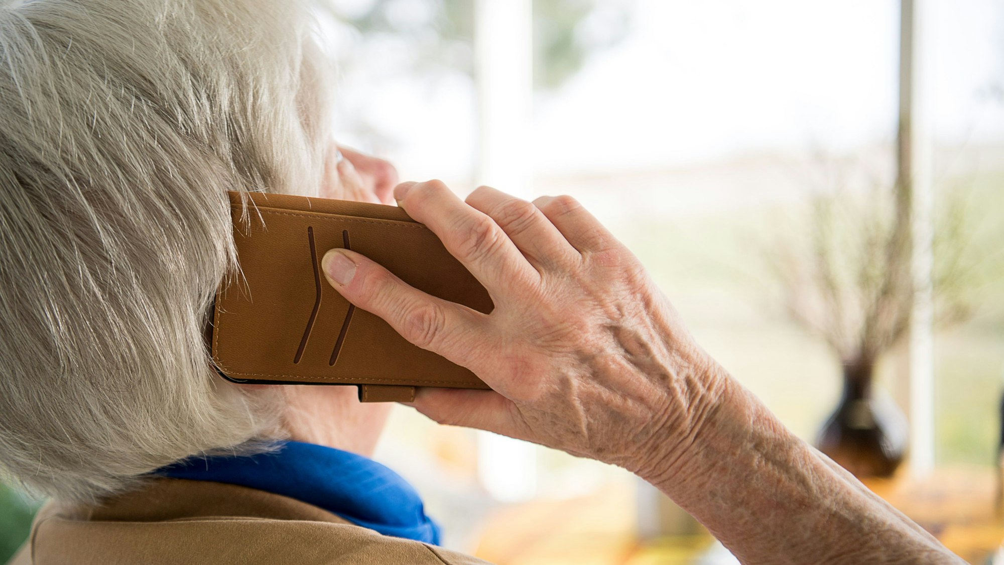 Eine Seniorin telefoniert mit ihrem Smartphone.