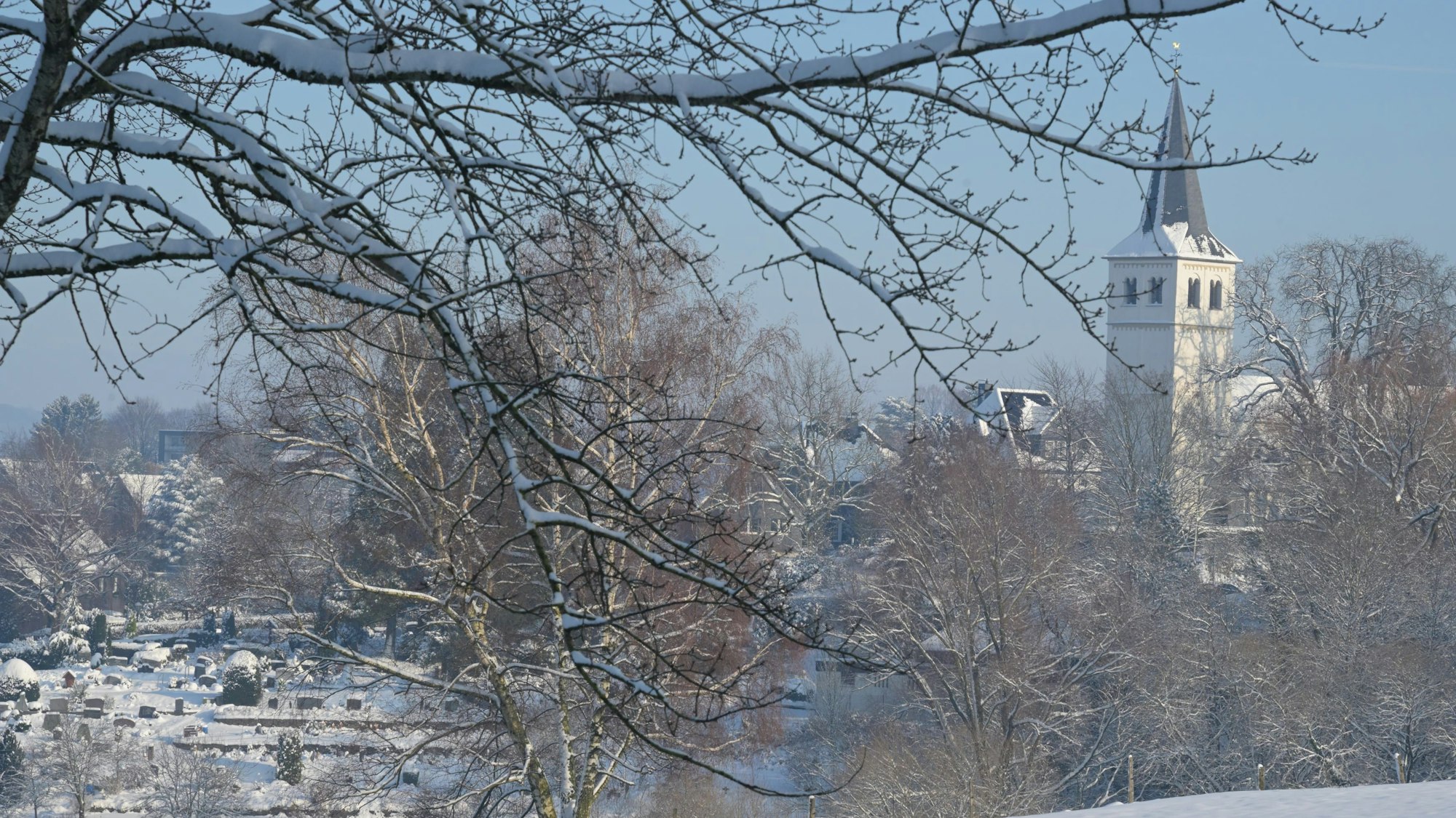Blick auf die verschneite Kirche von Bergisch Gladbach-Herkenrath.