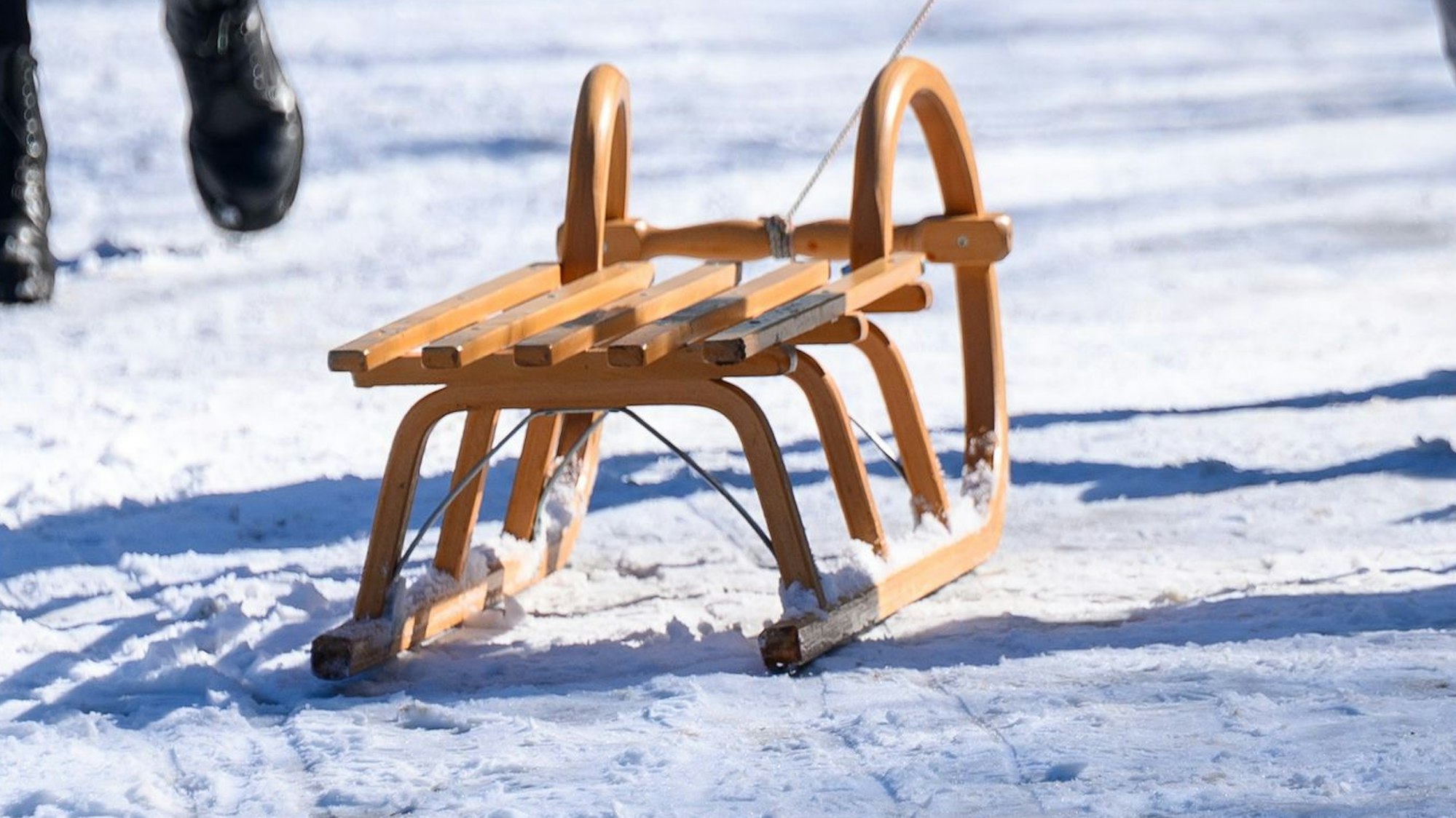 Ein Schlitten wird über einen vereisten und eingeschneiten Boden gezogen. Massive Schneefälle hatten NRW am Mittwoch getroffen. (Symbolbild)