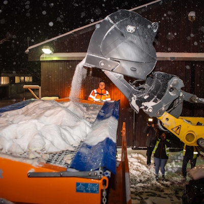 Ein Bagger befördert das Salz aus dem Lager in ein Streufahrzeug.