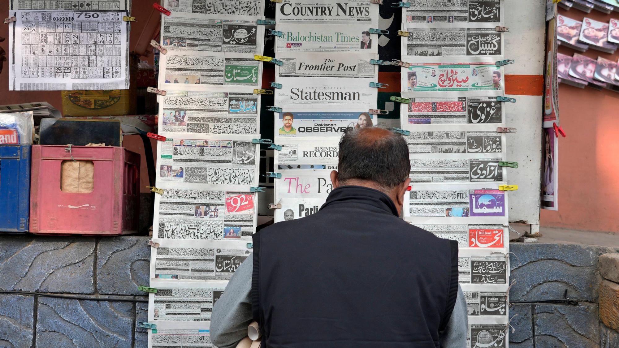 Ein Pakistaner liest an einem Verkaufsstand Tageszeitungen, die auf der Titelseite über den iranischen Angriff berichten.