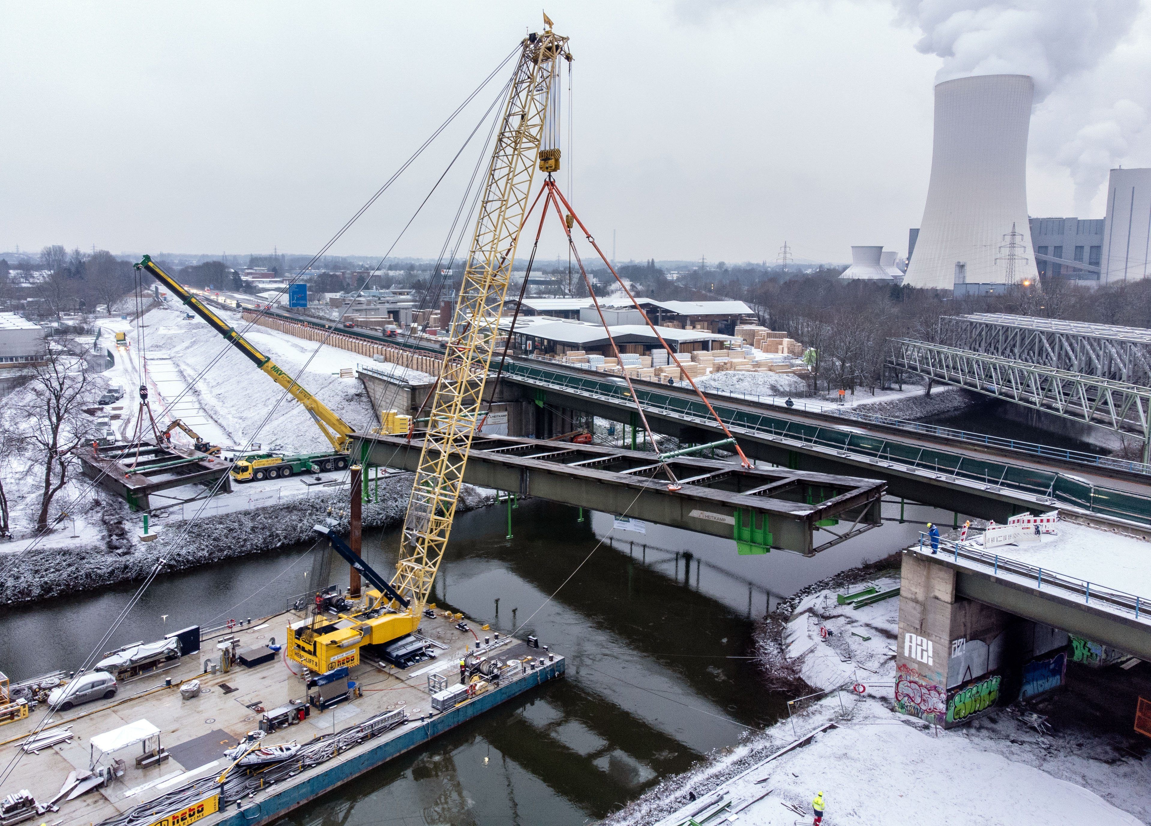 Ein schwimmender Kran ist am Rhein-Herne-Kanal an einer Autobahnbrücke im Einsatz.
