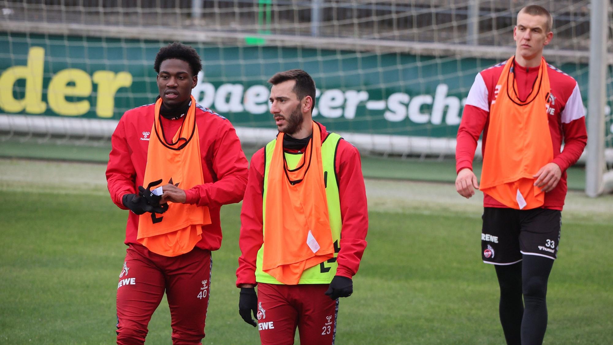 Drei der Spieler stehen auf dem Trainingsplatz.