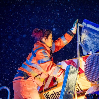 Das Bild zeigt Jasmin Bauerfeind, wie sie auf dem Auflieger steht und die Abdeckung zur Seite klappt.