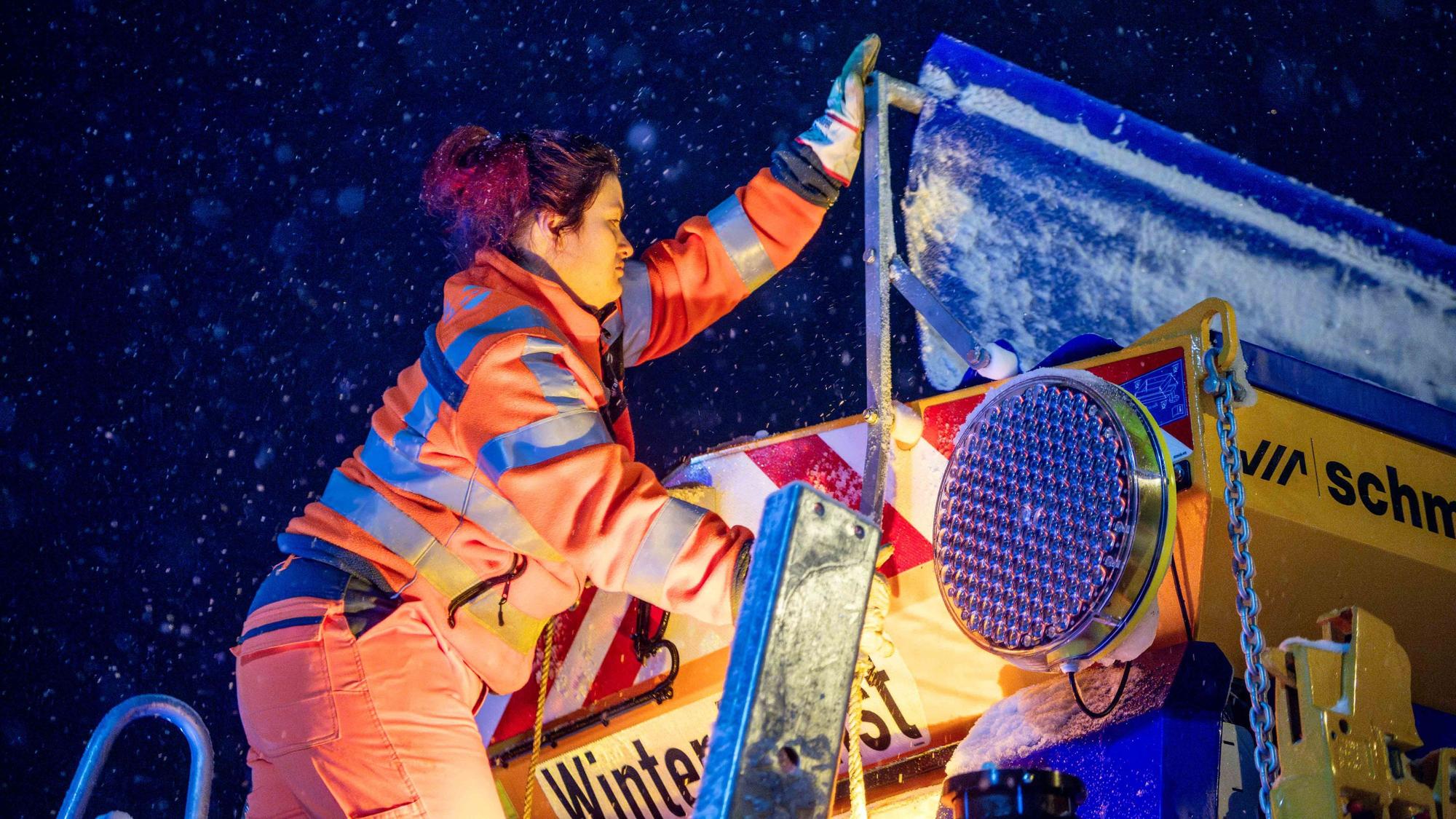 Das Bild zeigt Jasmin Bauerfeind, wie sie auf dem Auflieger steht und die Abdeckung zur Seite klappt.